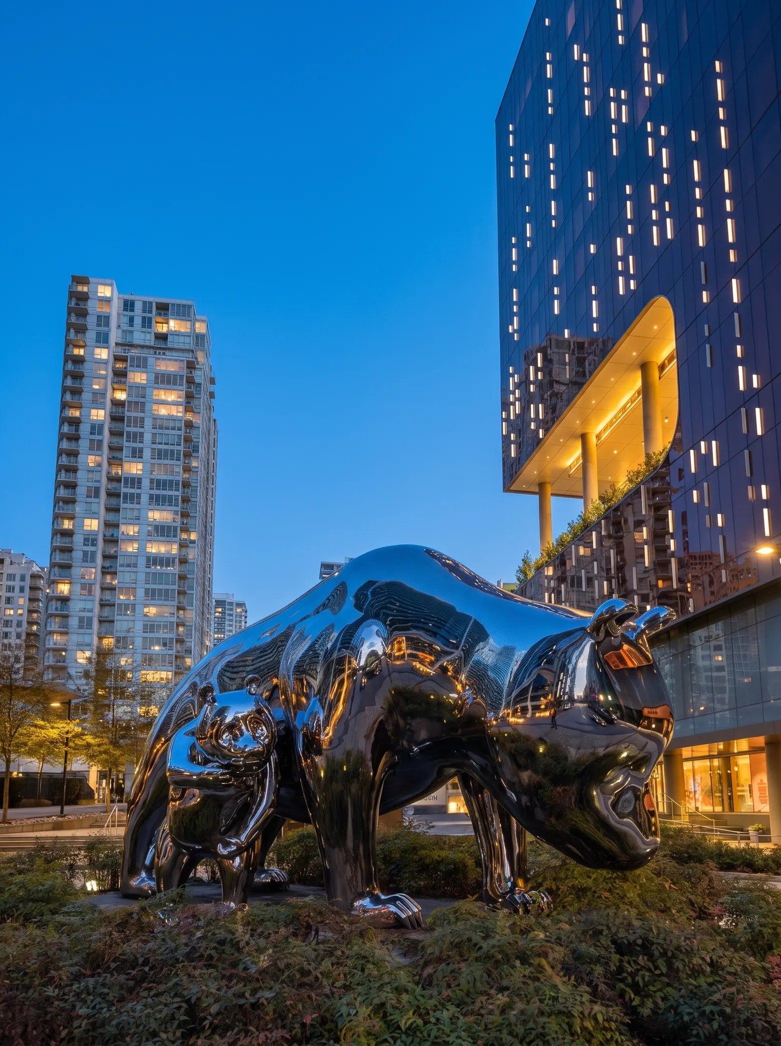 Chrome bear sculpture outside Parq Vancouver at dusk